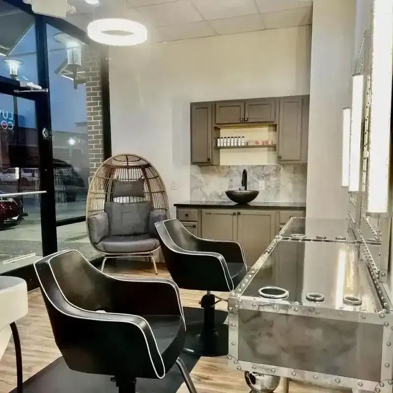 Cozy modern salon with chic chairs, unique lighting, and a stylish waiting area.