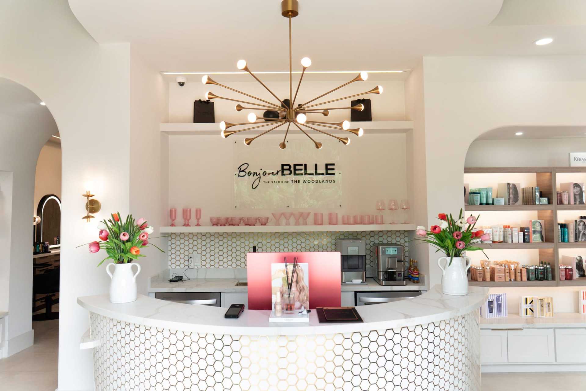 Salon reception area with modern decor and flower arrangements on the counter.