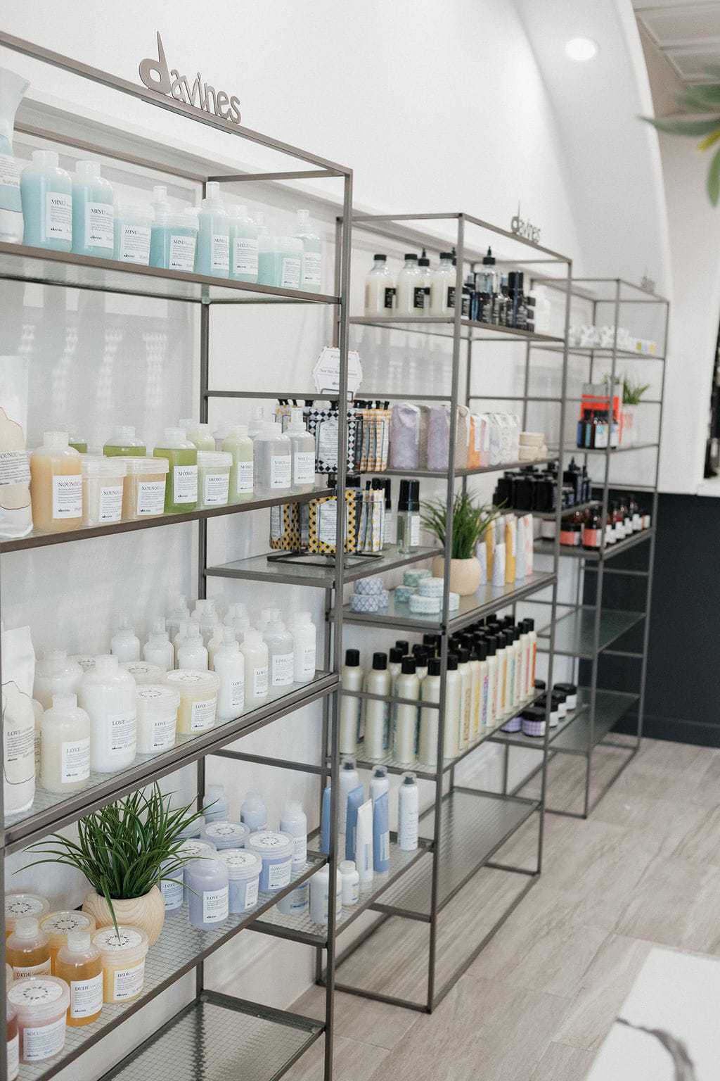 Shelves with various hair care products displayed in a modern salon setting.
