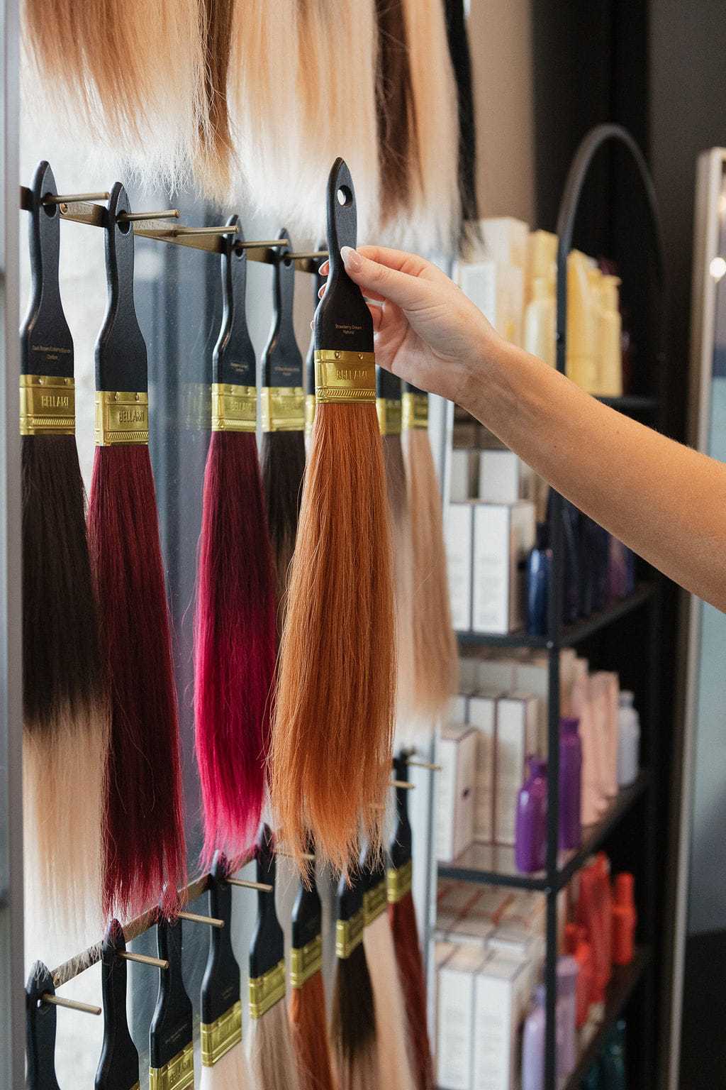 Paintbrushes with various bristle colors on display in an art supply store.