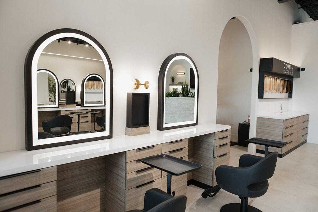 Modern salon with sleek styling stations, mirrors, and minimalist decor.