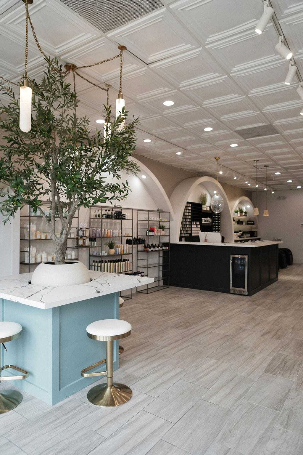 Modern cafe interior with archways, marble counters, and hanging lights.